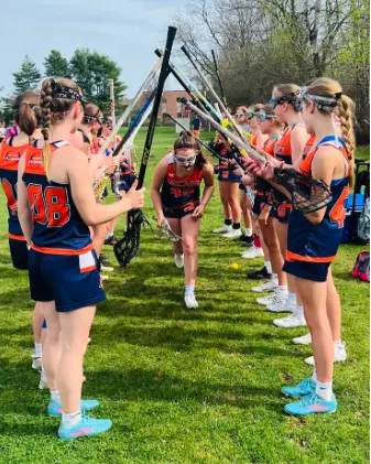 Echo Lacrosse players wearing navy and orange game uniforms