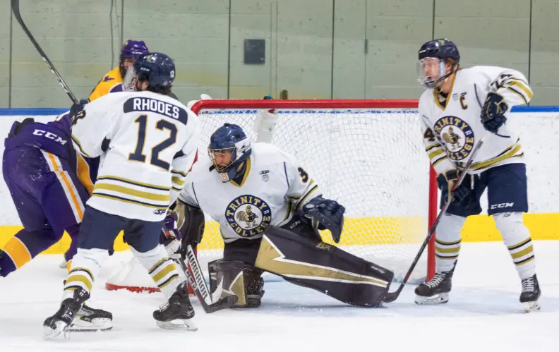 Trinity men's hockey players wearing white game uniforms
